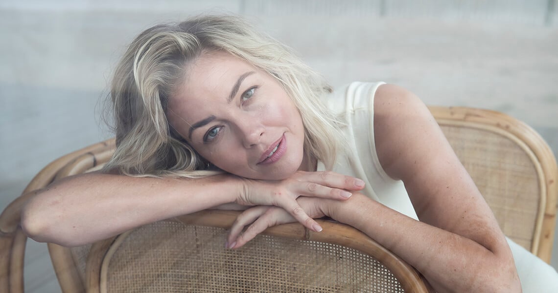 Blonde woman on chair looking to the camera