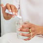 Woman pouring The Solution in glass