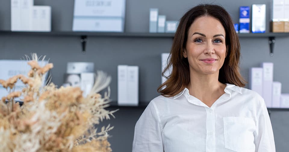 Skin Therapist standing in front shelves filled with The Solution packages